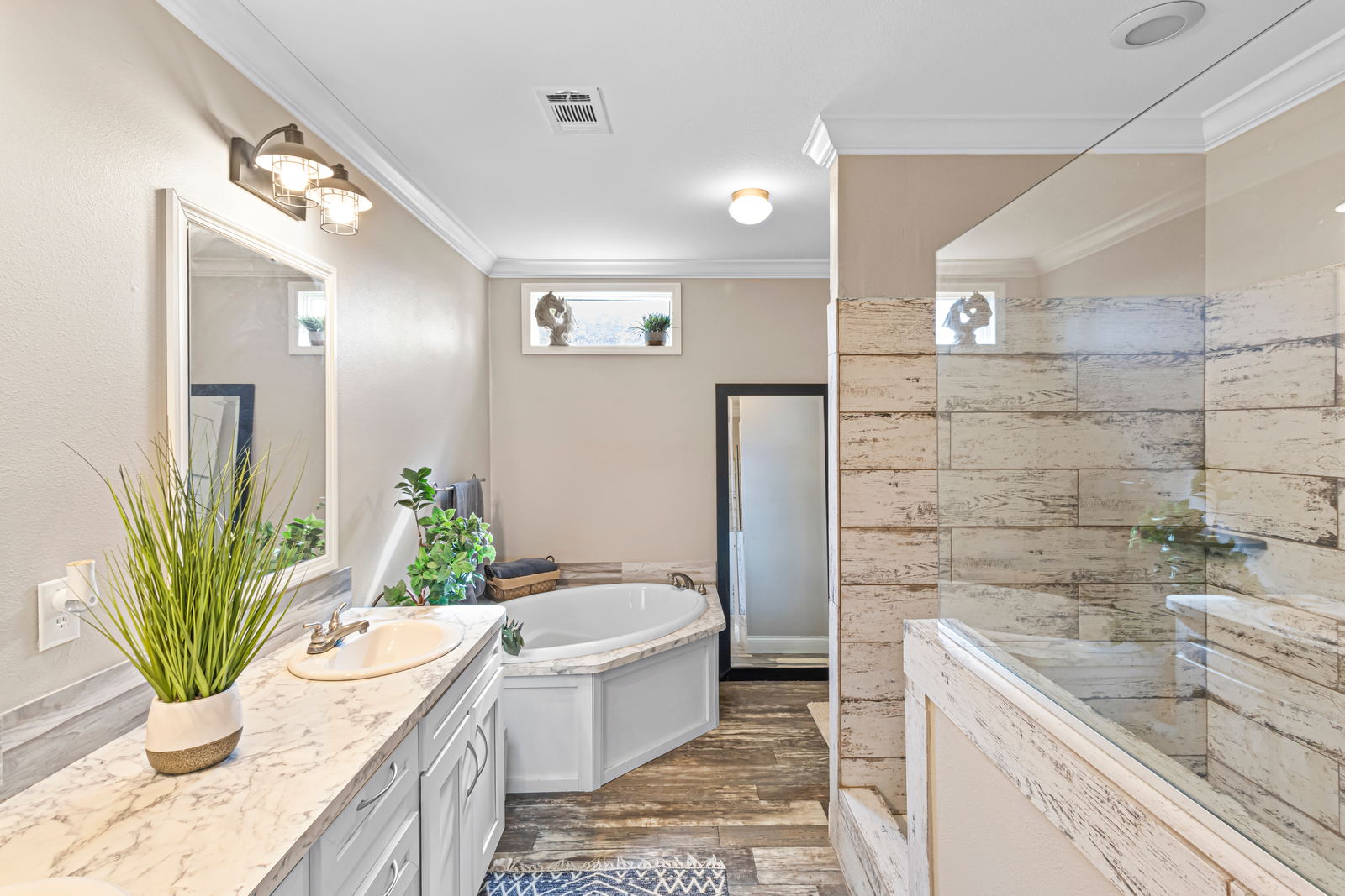 Primary bathroom with a garden tub, long vanity, and tiled walk-in shower